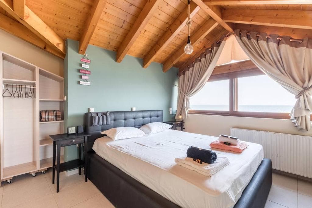 Wood-furnished bedroom with sea view in a Surf Apartments Artemida holiday apartment